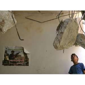 Palestinian Boy Looks Inside the Damaged House of Militants Moatasm 