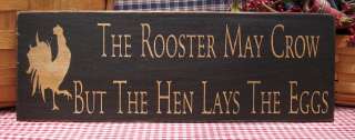 The Rooster May Crow But The Hen Lays The Eggs sign  